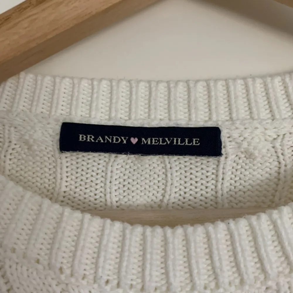 Mysig, avslappnad tjock kabelstickad drop shoulder-tröja i vit från Brandy Melville. Den är i bra skick, endast använd 3-4 gånger och är one size.  Ursprungligt pris: 38$ (US-dollar) Obs: köparen står för frakten!. Tröjor & Koftor.