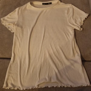 Enkel Ribbad Vit Lager 157,T-shirt - Enkel vit ribbad T-shirt med söta detaljer på kanterna/ärmarna. T-shirten är I storlek XS men tror även den kan passa en S, stor i stl. Köpt på Lager 157 för 100kr (nypris). Skick är som på bilden. Säljer då den inte har kommit till användning mera.🥰