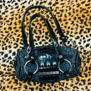 2000s rund guess väska - ✰*฿✩‧₊˚ läs gärna köpvillkoren innan ✰ rund väska från guess, vet ej om den är äkta därav priset ✰ knappt märkbara små fläckar på insidan (skriv priv för bild) annars i mycket bra skick ✰ FAST PRIS ✰ skicka ett meddelande om du har några frågor💋