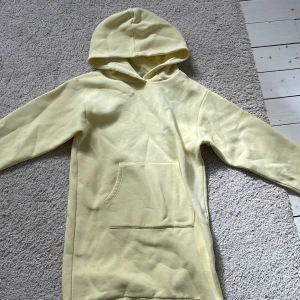 Lång hoodie  - En stor, lång , varm och bekväm gul hoodie med mjukt material inuti!Använd någon enstaka gång! Med en väldigt svag fläck på högra armen som jag tror går bort i tvättmaskinen! Och har en ficka där fram!👌🏼😍❤️
