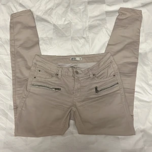 Beige jeans - Beige jeans med blixlåsfickor fram 