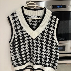 Hundtandsmönstrad väst - Hundtandsmönstrad väst, storlek M. Liten slits på sidorna.  Endast använd en gång.