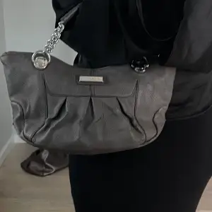 Jättefin grå Calvin Klein handväska med silvriga detaljer. Köpt på Sellpy därav äkthetskontrollerad💘 Bredd: 37cm, djup: 8cm, höjd: 16cm. Varan har använts flitigt och defekter förekommer. (Skriv för fler bilder)💘