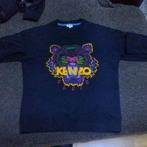 Kenzo kofta  - En svart Kenzo kofta storlek S med färg glad logo. Har använts ett par gånger är i okej skick passar bara inte mig. Gjord för men (kan dock passa Damer med unik stil)  Kan mötas upp i den centrala delen av uppsala