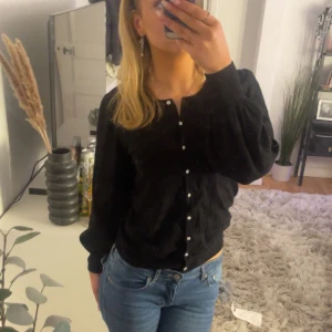 svart kofta med glitterknappar - jättefin kofta med lite puffärm, knappt använd, glitterknappar. Är i S men passar större då den är stretchig! Säljs inte längre