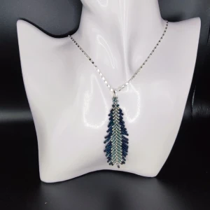 Handgjort halsband  - Min mamma tillverkar och designar egna smycken. Dessa är vävda i små glaspärlor. Hänget är 6.5 cm långt. Kedjan är 44 cm och i äkta silver. 