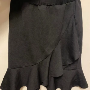 Kjol - Svart fin kjol som har en volang och överlappningsdetalj, snygg till sommar och fest med en fin topp, gullig, bekväm, använd ca 10 ggr