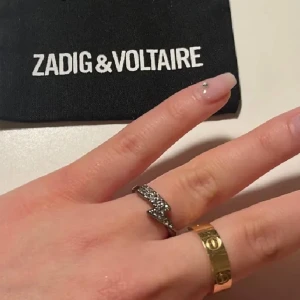 Zadig & Voltaire ring - Säljer denna ring då den inte kommer till användning. Säljs tyvärr inte längre hos Zadig & Voltaire. Den har tappat två nitar. Den har även rostat lite vid sidorna.