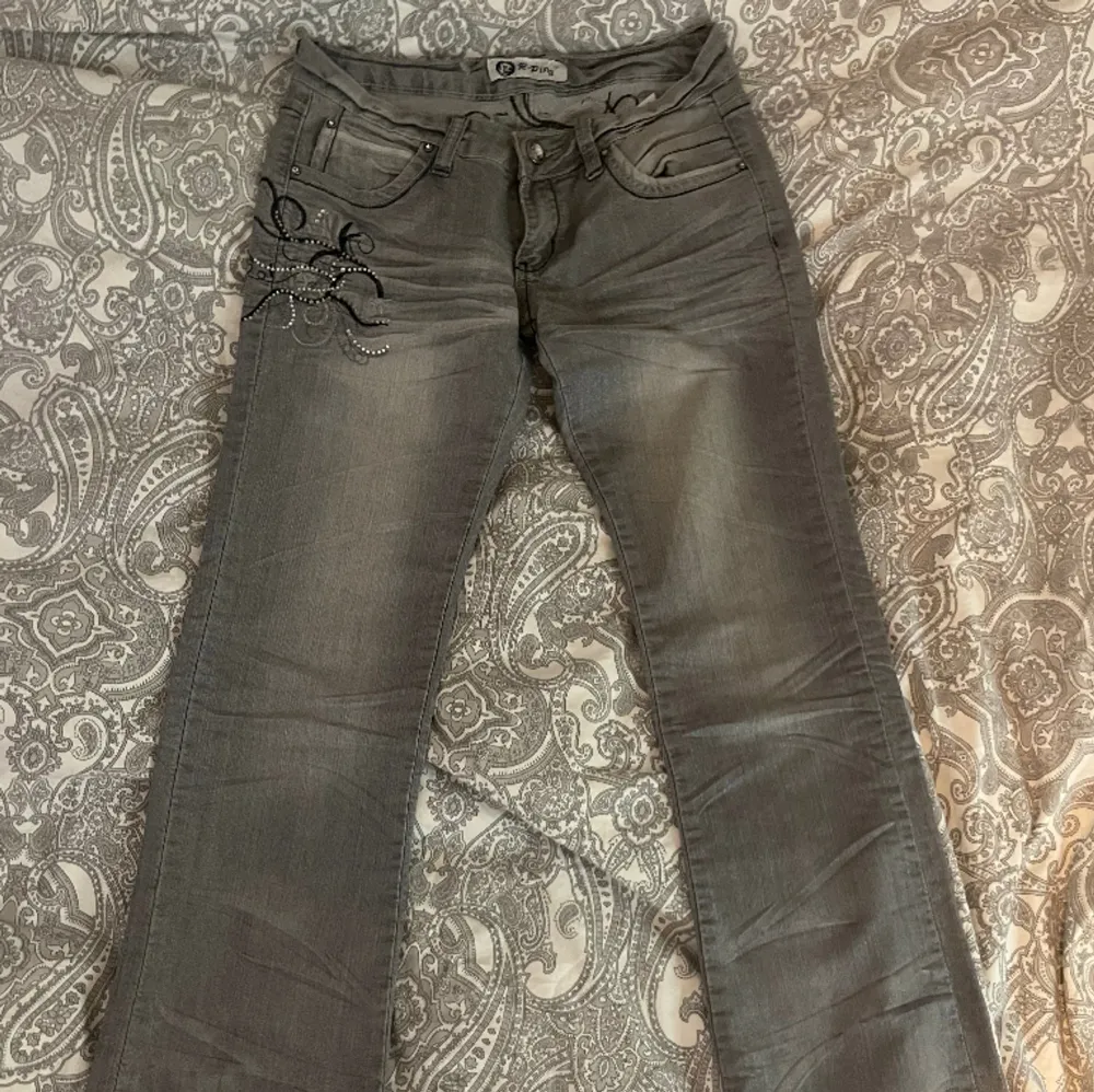 Lågmidjade gråa jeans med super snygga broderingar och stenar på. Köpta på Plick men aldrig använda av mig då dom inte passar. . Jeans & Byxor.