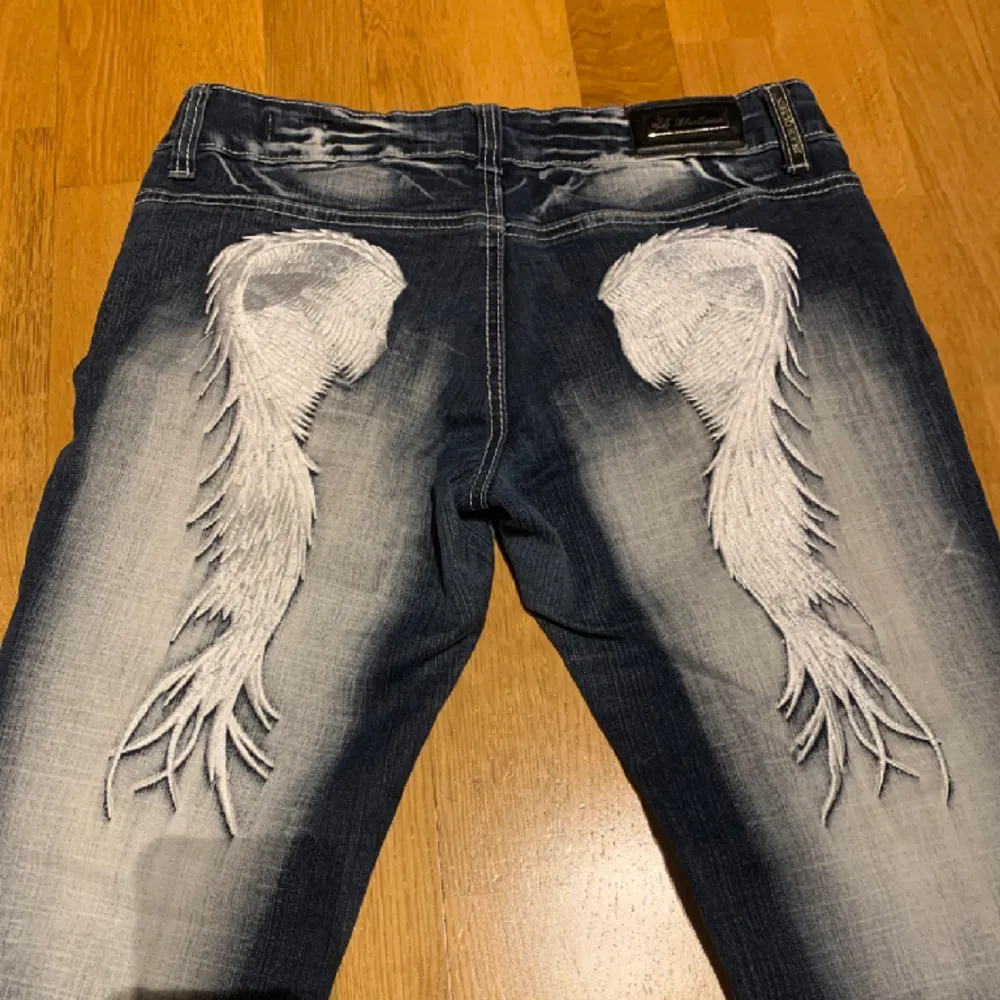 jätte coola low waist bootcut jeans med vingar på baksidan . Jeans & Byxor.