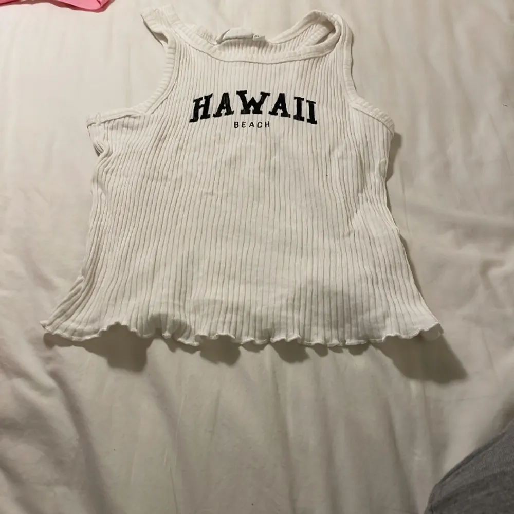 Ett linne där det står Hawaii . Toppar.