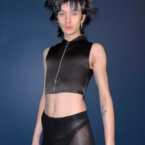 Sexig svart glansig väst - croppad tanktopväst i glansigt tyg, dragkedjan går att dra hela vägen upp. Stilren elegant tech rave basic. Går att matcha till allt, perfekt för vår höst o sommar på festival tex!🖤🖤💕✨🩸