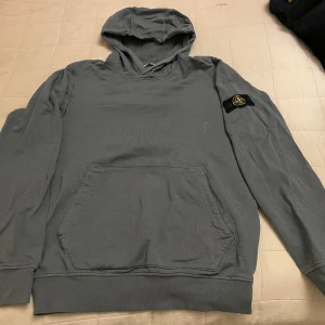 Stone Island hoddie, 170 - Gråblå Stone Island hoddie, junior, storlek 170. Som ny, använd ett fåtal tillfällen. 