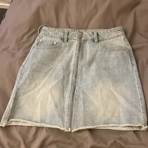 Jeanskjol - Jeanskjol säljes då den är för liten på mig, använd ett fåtal gånger! Mycket fint skick och har fina detaljer! 