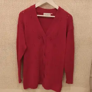 Rosa vacker stickad tröja i fint skick. Material 100% Bomull. Mått från ärmhåla till ärmhåla 49 cm x 2. Längd från axeln till nederkanten 73 cm.