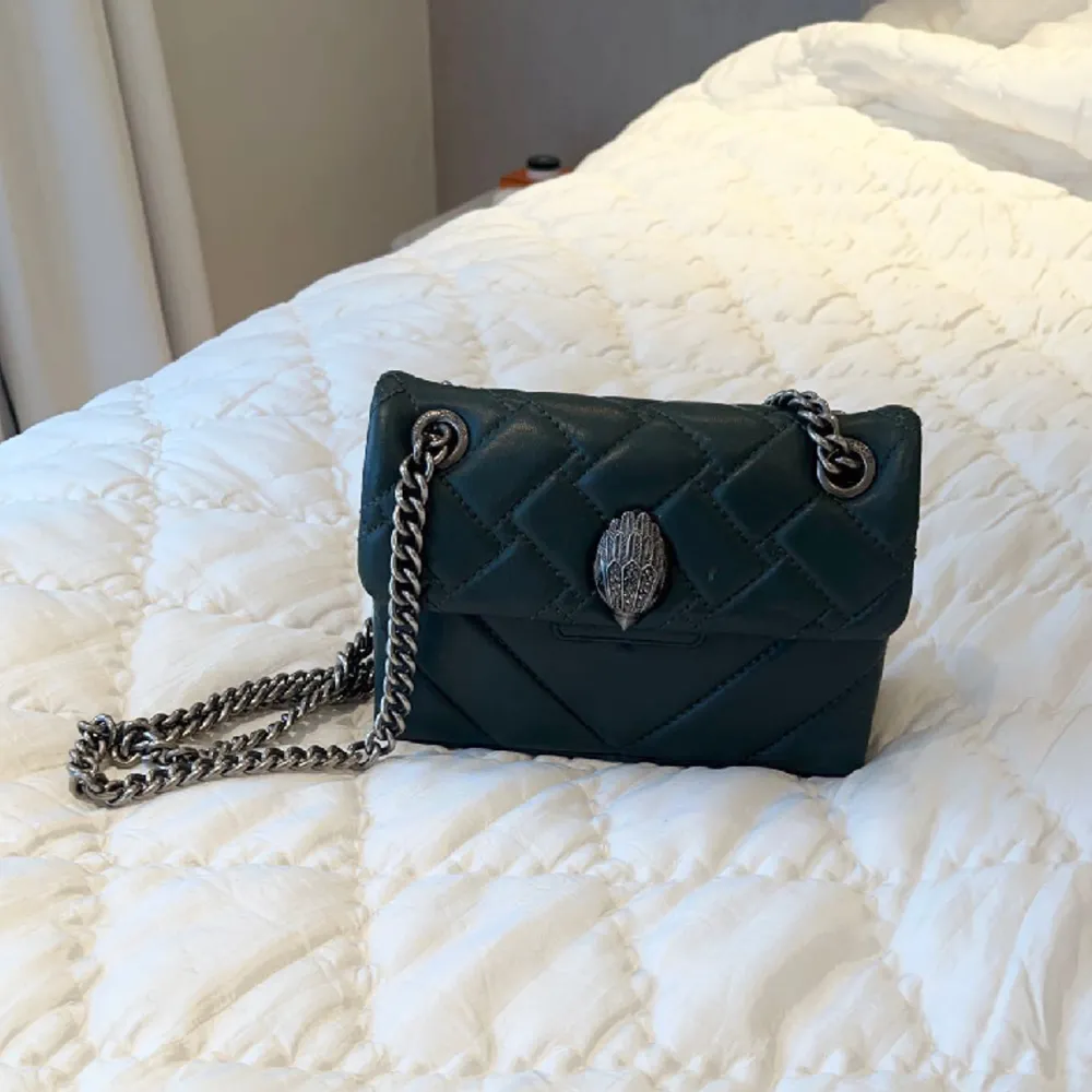 Säljer min gröna Mini Kensington Bag ifrån Kurt Geiger! Den är i bra skick förutom lite slitningar under väskan på kanterna. Tillkommer dust bag, skriv privat om du vill kolla på fler bilder☺️💞. Väskor.