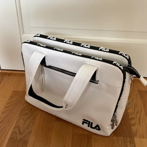 Fila datorväska - 14’ (34*25cm) Två utrymme för dator och en stor utrymme mellan dem för små grejer. Axelrem ingår. Knappt använt. Köpt pris 400