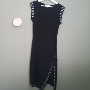 Michel Kors klänning - Väldigt fin klänning som är smickrande för kroppen. Några plitar saknas däremot. Klänningen är använd vid 2 tillfällen.