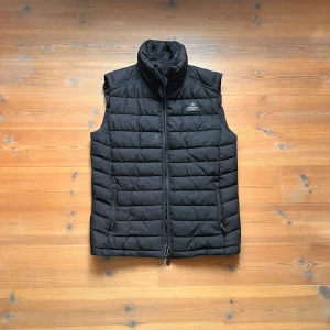 retro väst - Dunväst från Superdry i äldre modell, fint dun utan defekter och fortfarande lika slitstarkt material. Passar till allt!