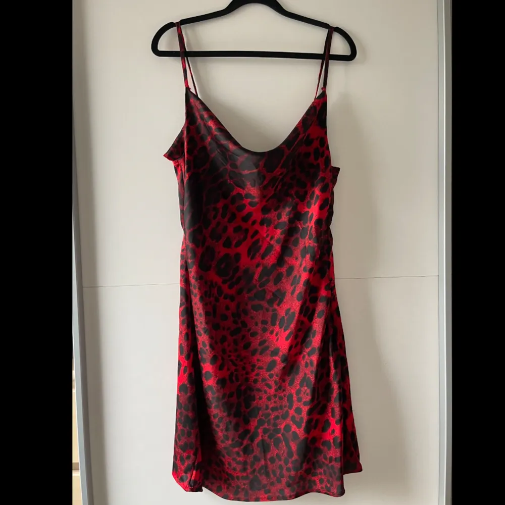 Röd leopard print mini klänning från Boohoo i silk material. Köptes sommaren 2023 och har endast använts 1 gång. Bra skick, kan dock ha ett fåtal trådar som sticker ut. Obs. Kan tvättas och strykas om önskas 🤗. Klänningar.