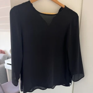 Blus - En svart blus ifrån Gina i storlek 34. En litet knapp som ska sitta bak har lossnat men går att limma dit en ny, därför säljer jag billigt! Skriv om ni har funderingar.🩷