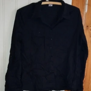 Svart figursydd skjorta - Svart figursydd skjorta från LaRedoute i storlek 44. 64 cm lång från axeln.  Sparsamt använd. 