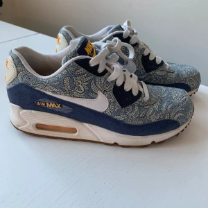 Nike Air Max 90 - Nike Air Max 90 i blått mönster med gula detaljer. Mycket fina skor i bra skick. Dom är använda men väl bevarade. Skulle må bra av en tvätt på sulorna, storlek 38,5💕