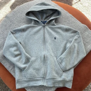 Ralph lauren zip hoodie - En Ralph lauren zip hoodie i väldigt bra skick. Använd fåtal gånger 9.5/10 skick. Bara att höra av dig om du undrar något