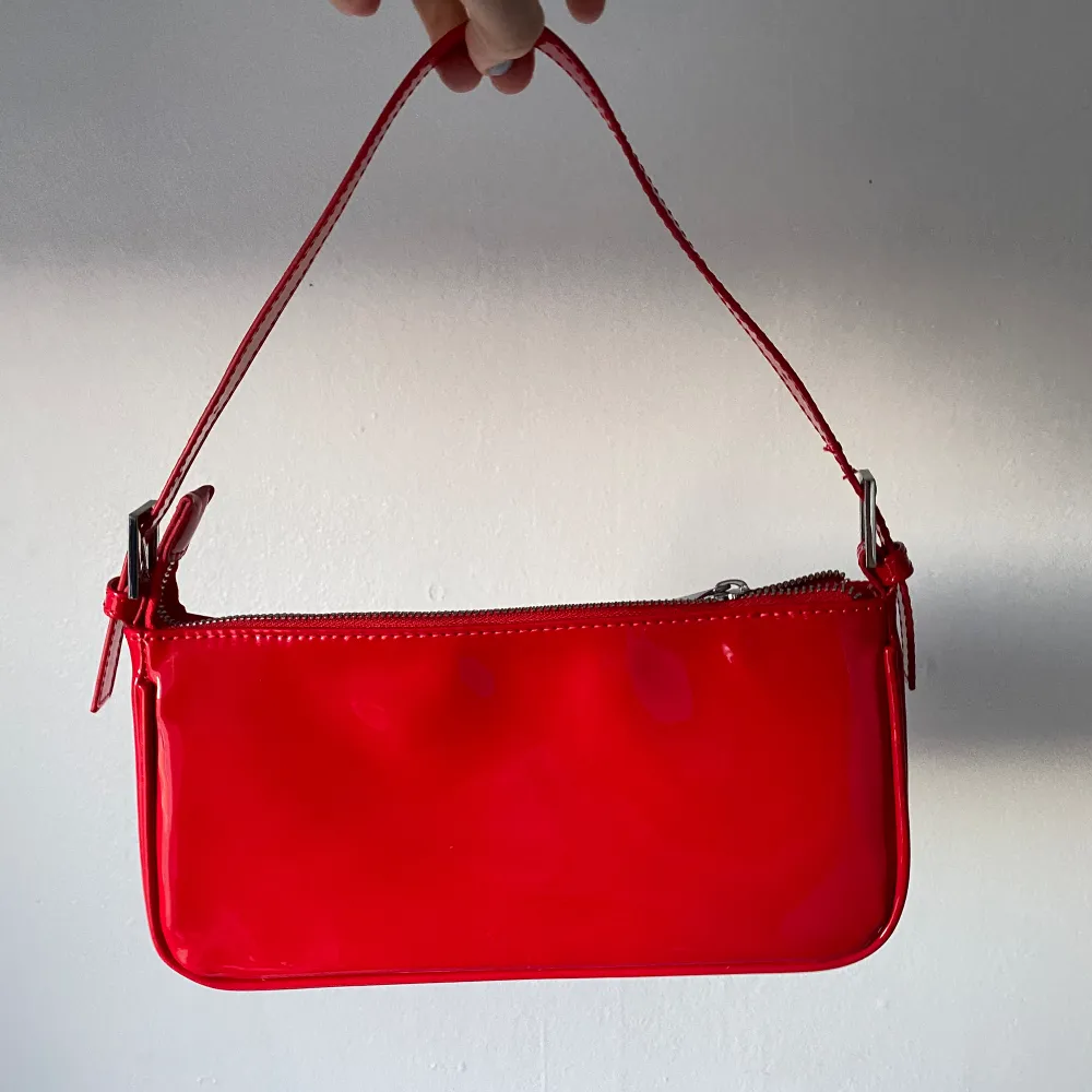 röd glossy axelremsväska, färgen är mer klarröd men super snygg, perfekt med röda tights eller skor 💋 köparen står för frakt. Väskor.