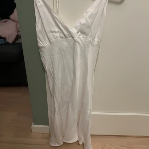 Zara klänning - Vit, kort zara klänning i storlek S men passar nog även XS då axelbanden är reglerbara beroende på hur hårt man knyter i ryggen 🥰 Tyget är lent, dock behöver den strykas 💕 Den går ner över rumpan och lite till på mig som är 163/64 cm