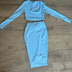 Ljusblå kjol ribbad och med slits och långärmad U-ringad tröja Mjukt material  Bra skick 