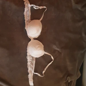 Vit spets BH - !Det finns två olika! 1st 75C & 1st 75C! Jättefin vit spets-BH med rosetter. Den har lite vaddering. Knappt använd, men lite ihop tryckt pga förvaring. Fortfarande helt användbar!