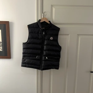 Moncler gui väst - En väldigt fin äkta moncler gui väst som har storleken ”3”. M-L. Men passar medium bättre. Köpt från nk. Skicket är 9/10. Kontakta vid minsta lilla fråga eller fundering.