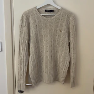 Ralph Lauren stickad tröja - En beige stickad Ralph Lauren tröja i storlek s. Den är använd men fortfarande i bra skick. Nypriset ligger på ca 2100 kr. Säljer för 500 kr. Passar ca 175 cm.