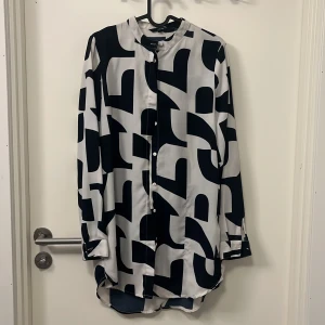 Lång blus/klänning - Lång blus/klänning, fantastisk fin. Funkar att ha som den är med bara cykelbyxor under eller öppen med linne & cykelbyxor.  Någon tråd har dragits etc (se sista bilden), men inget som stör.