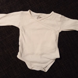 Omlottbody strl. 56 - Vit omlottbody i storlek 56 från Basic U. Perfekt basplagg. I fint begagnat skick, inga hål eller fläckar. Unisex  Tvättad i parfymfritt tvättmedel och utan sköljmedel.