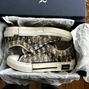 Dior b23 - Säljer ett par dior b23 i använt skick  7/10 Box och dustbag kommer med Nypris 11k Limmade på ett par ställen men inget som syns riktigt 