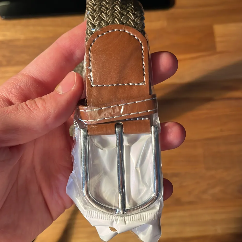 Säljer det här nya och oanvända flätade bältet. Hela bältet bortsett från metallbiten är ca 105 cm långt, men kan stretchas ut till en större storlek. Pris: 69 kr. . Övrigt.