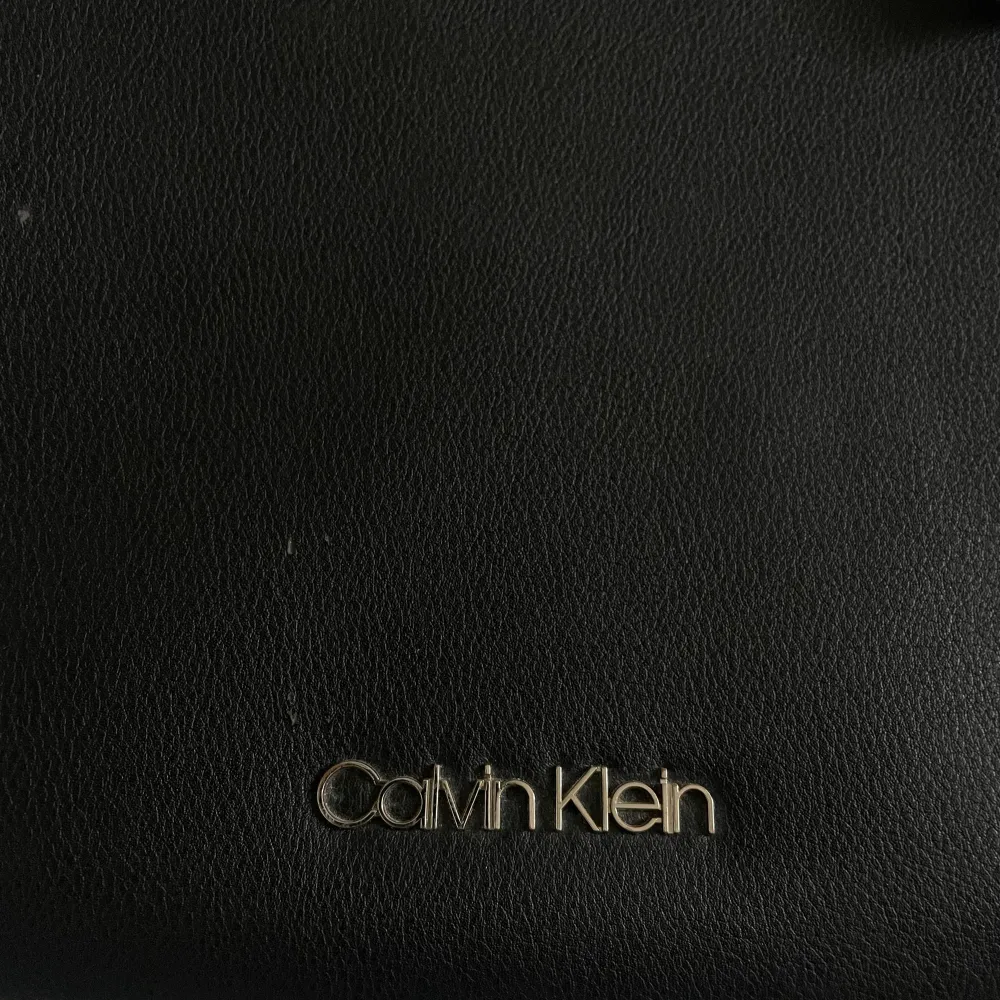 Jätte fin och stor handväska från Calvin Klein, perfekt som skolväska eller ens dagliga väska. Jätte bra skick, med två fack, varav ett av de går att stänga med dragkedja. Har små ”fläckar” av skinn som lossat, (bild 3). Modelen finns inte längre. . Övrigt.
