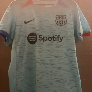 Barcelona tröja säsongen 23/24 - Barcelonas tredje tröja från säsongen 23/24 med Joao Felix på ryggen, som var på lån från Atlético Madrid. Tröjan är i storlek M och sparsamt använd.