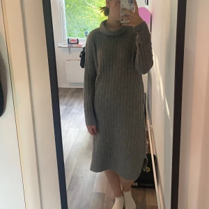 Stickad klänning  - Grå tjock stickad klänning med polonake, varm till vintern och väldigt mysig, bra skick, stor i storleken 