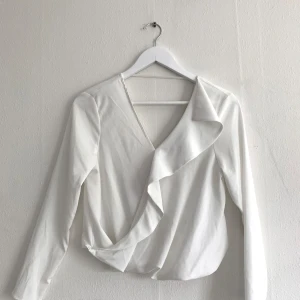 Vit långärmad blus - V-ringad bak och fram. 