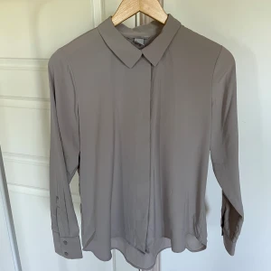 Skjorta H&M  - Helt ny skjorta från H&M. Storlek 40. Endast legat nedpackad så tog bort lappen när jag tvätta den. Grå/beige.