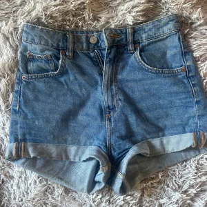 Blåa mom jeansshorts  - Et par blåa mom jeans shorts med högre midja som är köpta på H&M. Har använt dem en hel del men dem är inte trasiga någonstans och inga fläckar. Säljer för att dem är för små för mig som har storlek S på underdelar💕