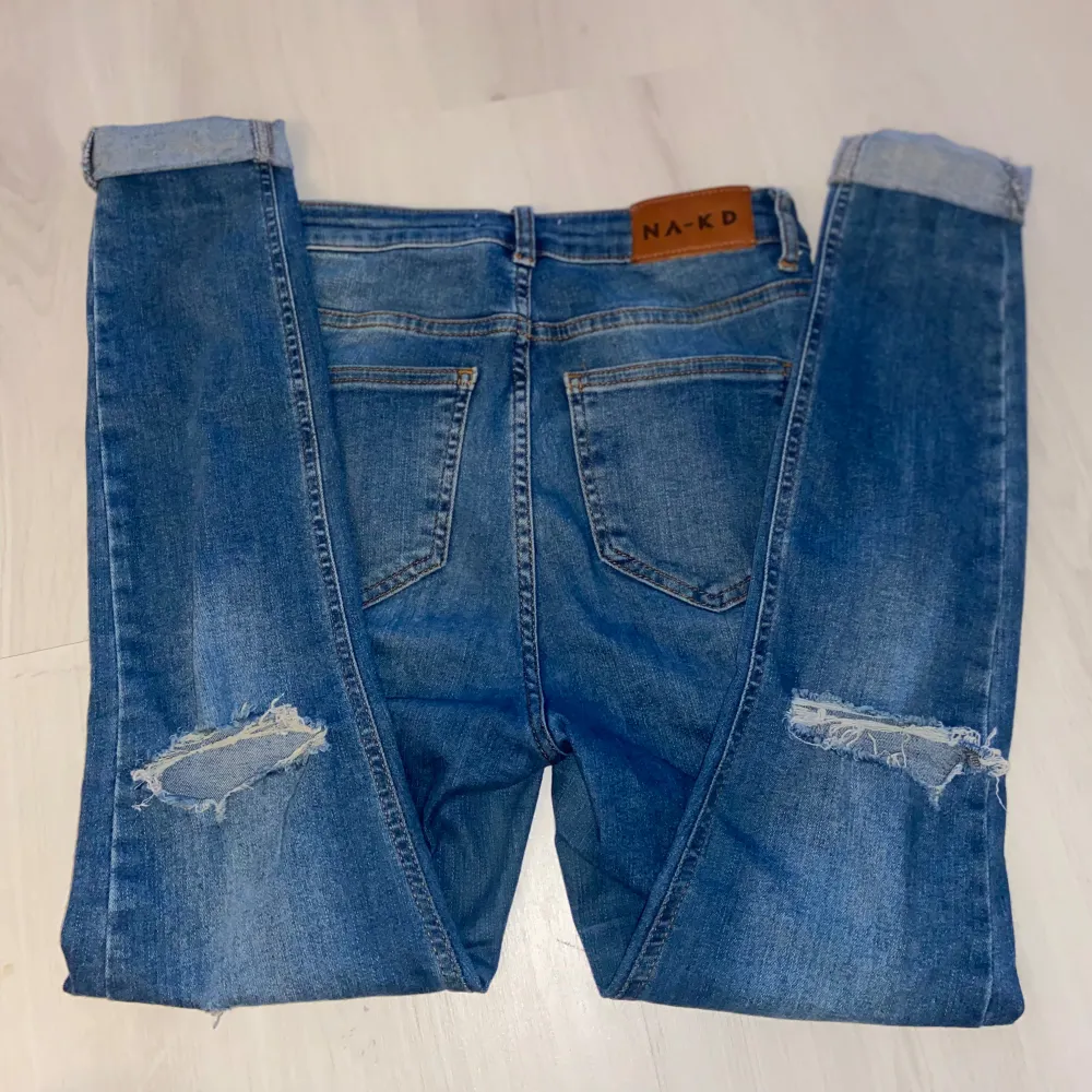 Ett par jeans från NA-KD med slitningar storlek S (Högmidjade)  Lyckas inte finna några anmärkningar utöver slitningarna som modellen ska ha. Jeans & Byxor.