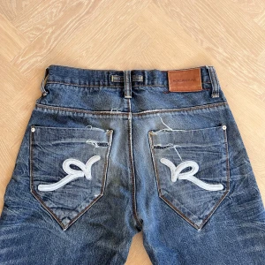 Rocawear loose jeans - Storlek w30  Loose jeans i bra skick Mått: Längd 109cm Midja: 41cm Innerben: 83cm Lårbredd: 28 cm Benöppning 23cm Distressed design och lite heelbite  Tveka inte att höra av dig om du har några frågor!