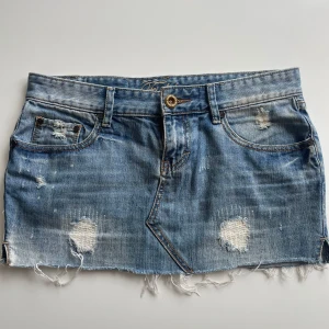 Jeanskjol - Säljer en jättesnygg lågmidjad jeanskjol som tyvärr var för liten på mig, den köpets här på Plick. Midjemått tvärs över: 42 cm. Längd: 30 cm.