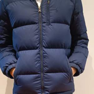 Säljer denna mörkblåa Polo Ralph Lauren jackan, storlek 164 (14-16 år), skick: 9.9/10. Säljer denna jacka då den inte passat efter ett fåtal användanden. Modellen är 173 cm väger 62 kg