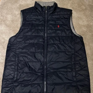 Ralph lauren väst - Västen är i nyskick och knappast använd . Storlek xs  . Västen är vändbar och är i blå och grå. Finns i Göteborg. Pris 850kr