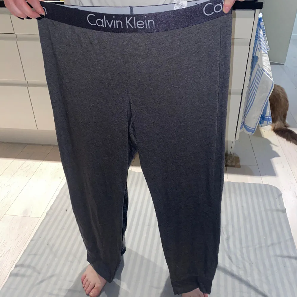 Gråa mjukisbyxor från Calvin Klein.  Säljes för byxorna är för stora. . Jeans & Byxor.